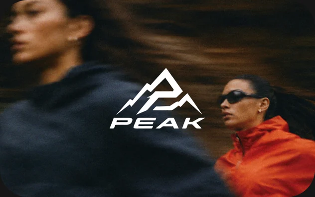 Twee hardlopers in beweging onder het Peak-logo